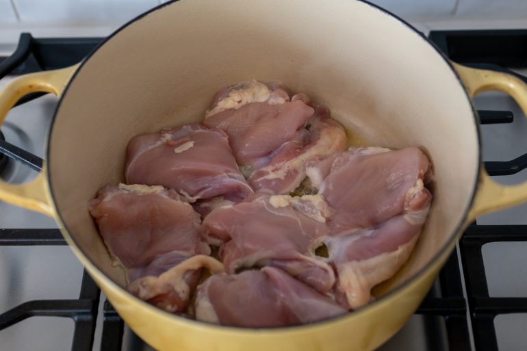 Raw chicken in a yellow pot.