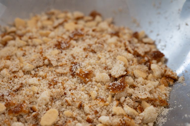 Crumbled cornbread in a big metal bowl.