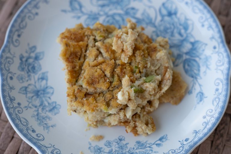A scoop of cornbread dressing on a plate.