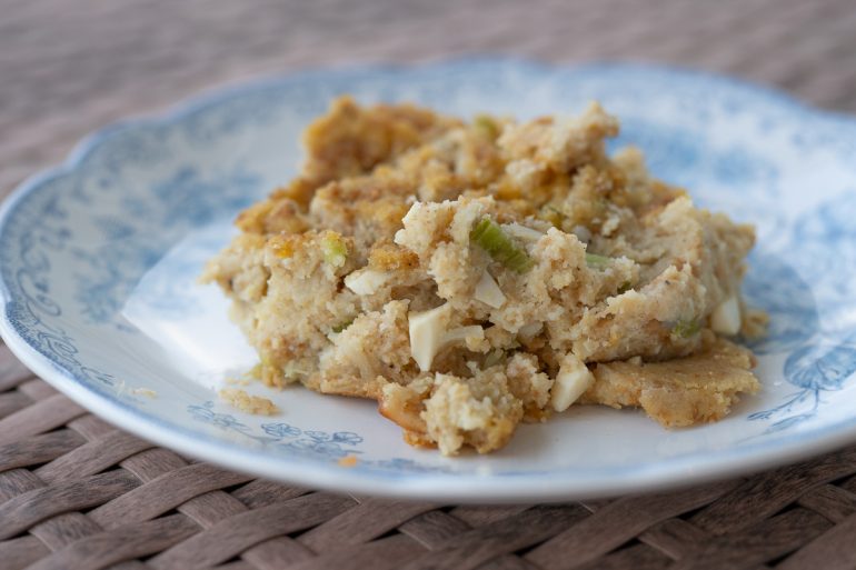 Cornbread dressing scooped onto a blue and white plate.