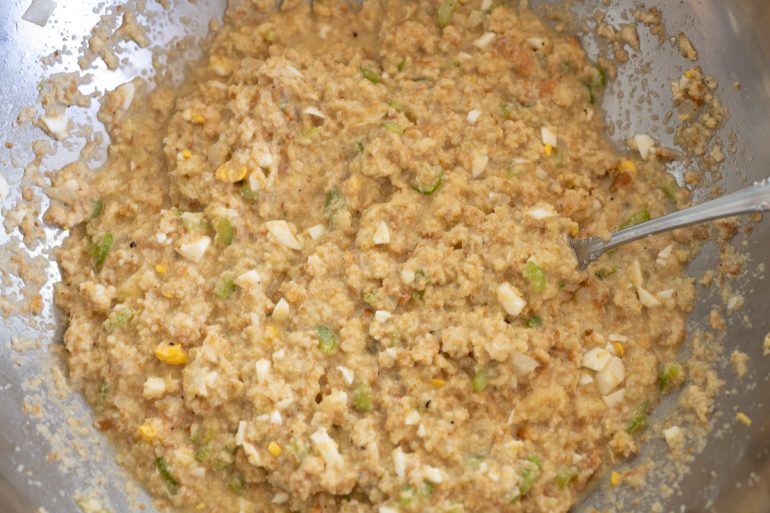 A big silver bowl with a wet cornbread dressing mixture.