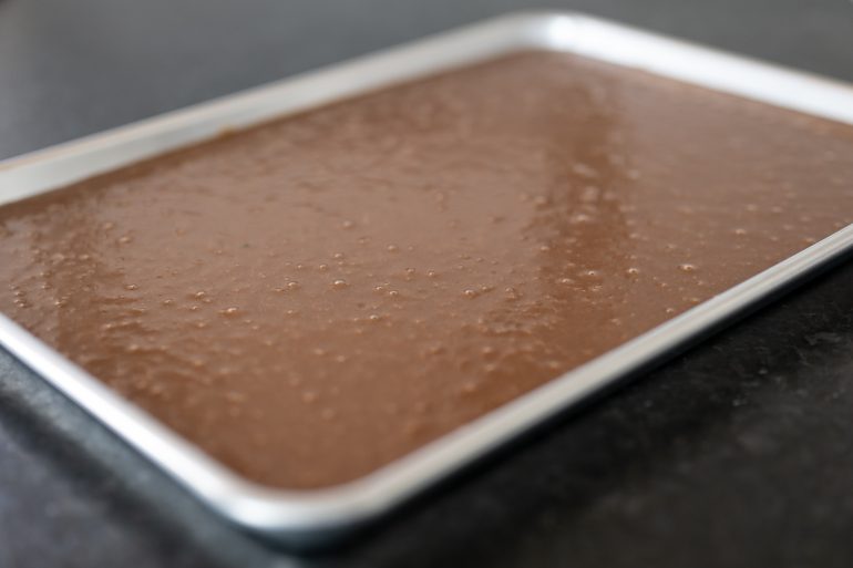 Batter spread in a jelly roll pan for Texas Sheet Cake.