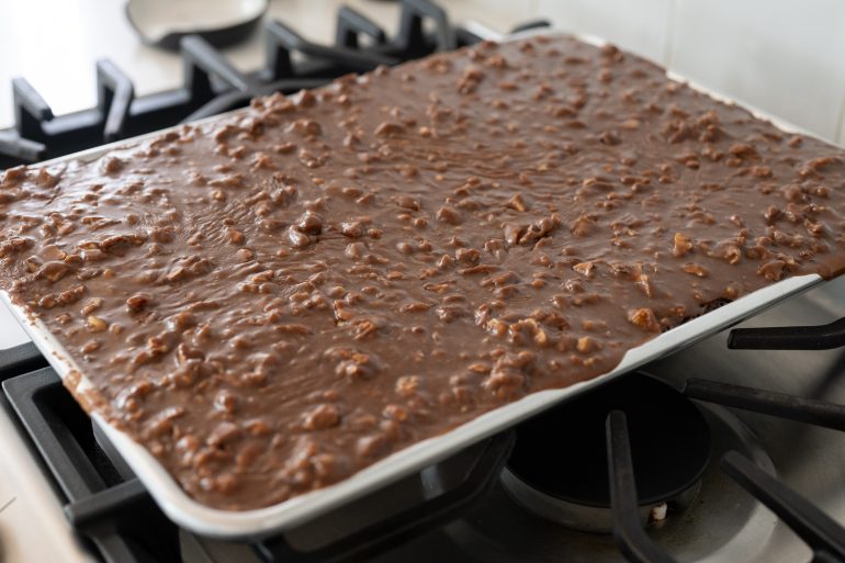 Close up of an Old-fashioned Texas sheet cake with pecans in the icing.