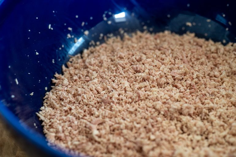 A bowl of smoked turkey processed in a food processor. You can see that although the turkey is finely chopped it still has texture and its not mushy.