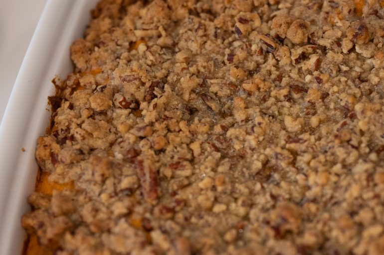 Top view of sweet potato casserole with a golden brown pecan topping.