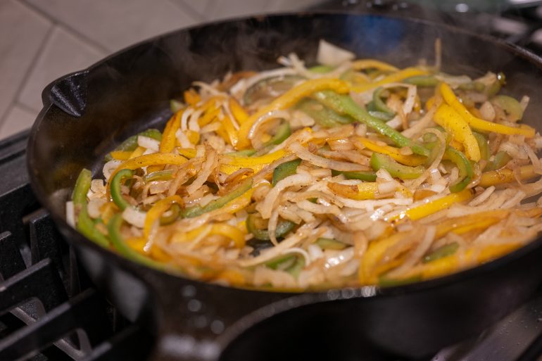 onions and bell peppers in a cast iron skillet.