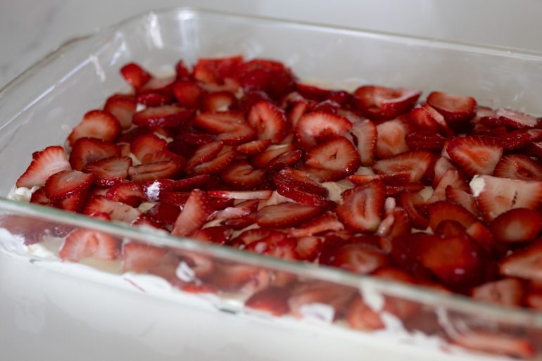 Sliced strawberries as one of the layers on a strawberry icebox pie. 